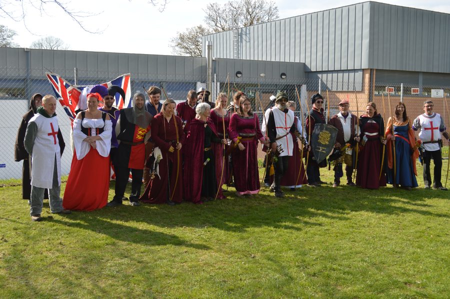 A large group of archers in historical costumes posing together